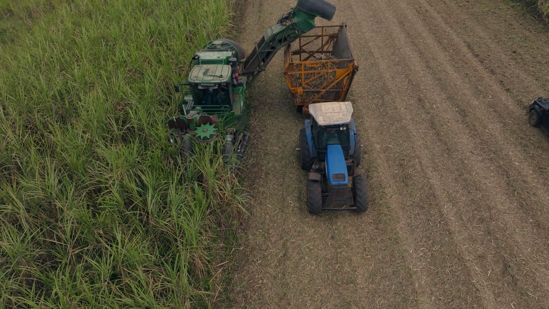 Harvester loading a tractor wagon, from above