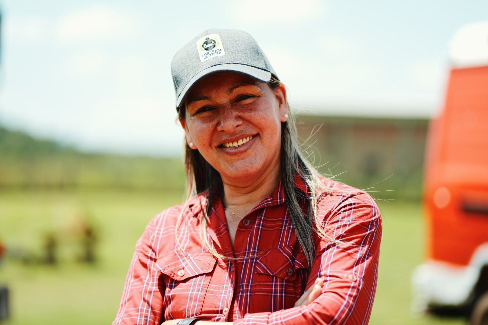 C.O.R.A. member smiling beside the co-op trucks
